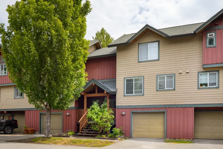 Townhome / multi-family property featuring board and batten siding, a garage, and roof with shingles