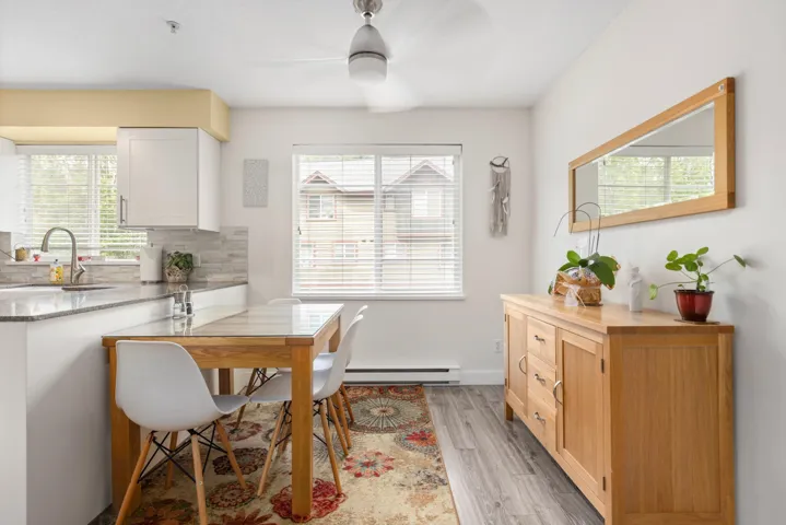 Dining area featuring baseboard heating, ceiling fan, plenty of natural light, and light wood-type flooring