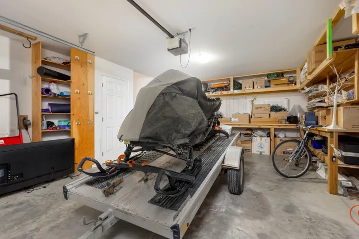 Garage featuring a garage door opener and a workshop area
