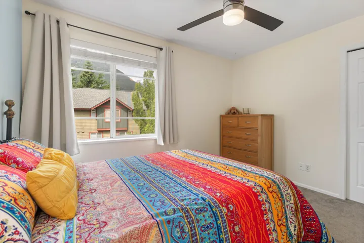Carpeted bedroom featuring a ceiling fan