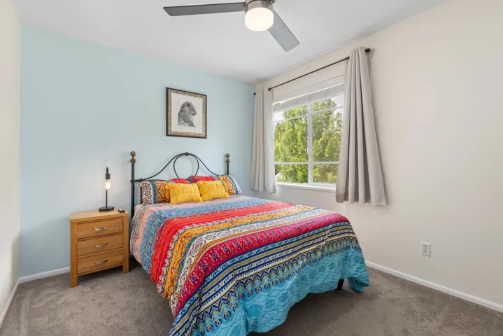 Bedroom with light carpet and ceiling fan