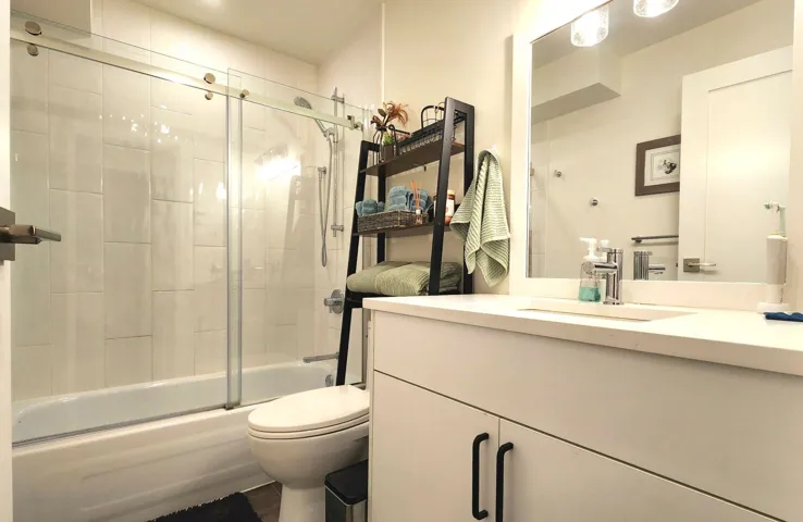 Bathroom featuring vanity, toilet, and shower / bath combination with glass door