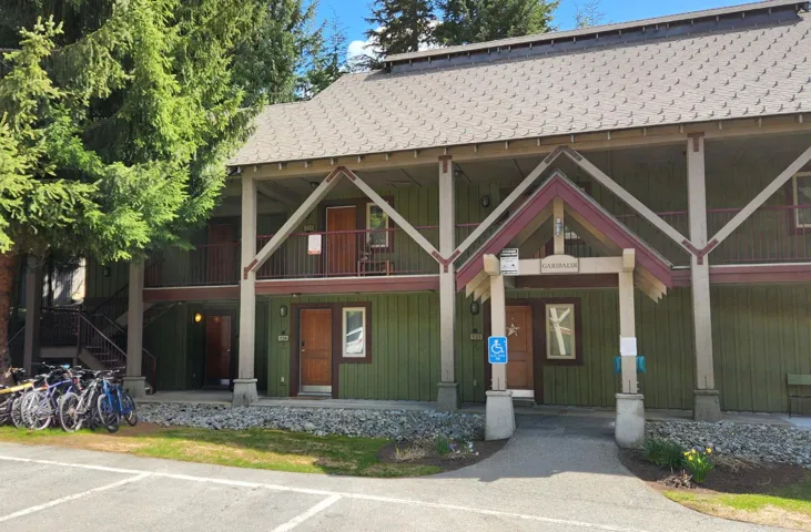 View of front of home featuring covered porch, a shingled roof, and a balcony