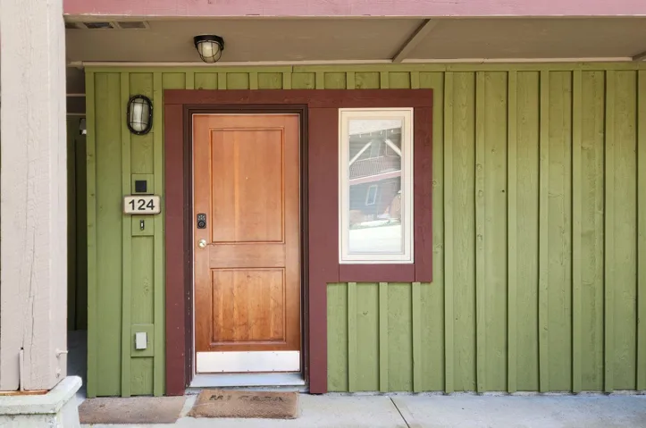 View of exterior entry with board and batten siding and visible vents