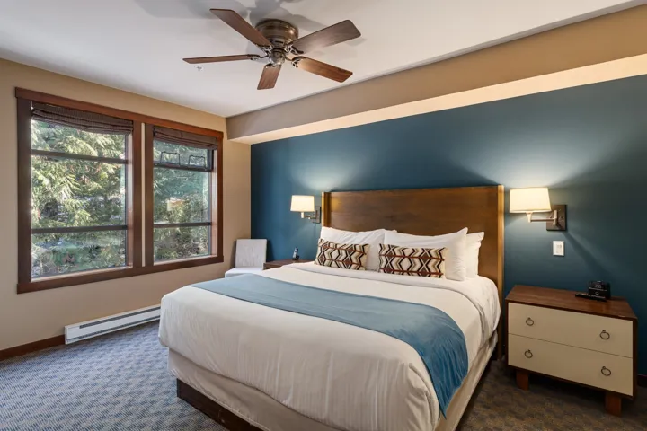 Carpeted bedroom featuring baseboards, baseboard heating, and ceiling fan