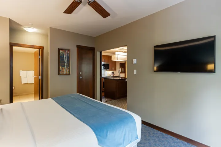 Bedroom featuring a ceiling fan, baseboards, and connected bathroom