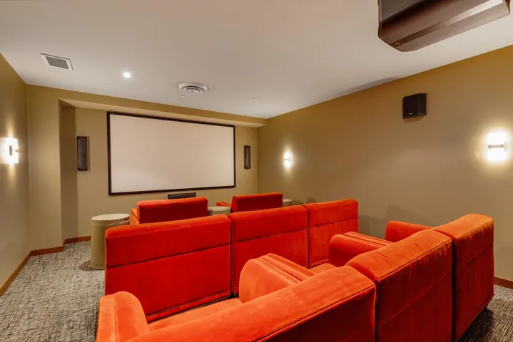 Carpeted home theater featuring visible vents and baseboards