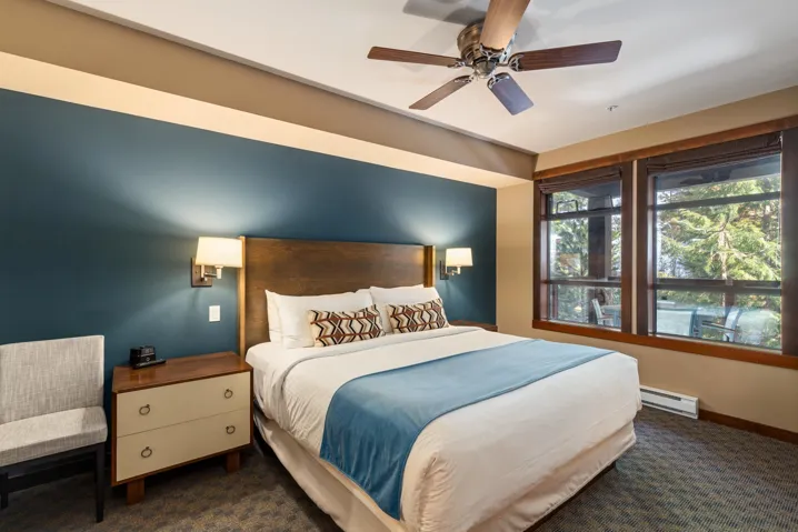 Bedroom with baseboard heating, a ceiling fan, baseboards, and dark colored carpet