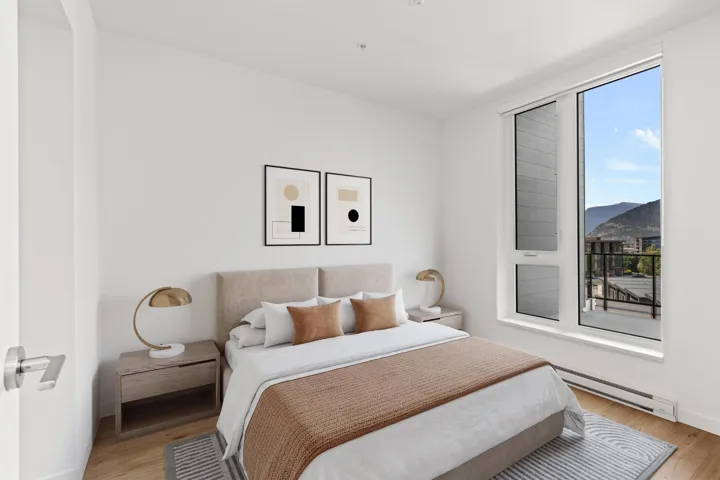 Bedroom featuring a baseboard radiator, light wood-style flooring, and a mountain view