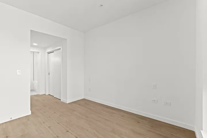 Empty room with light wood-style flooring and recessed lighting