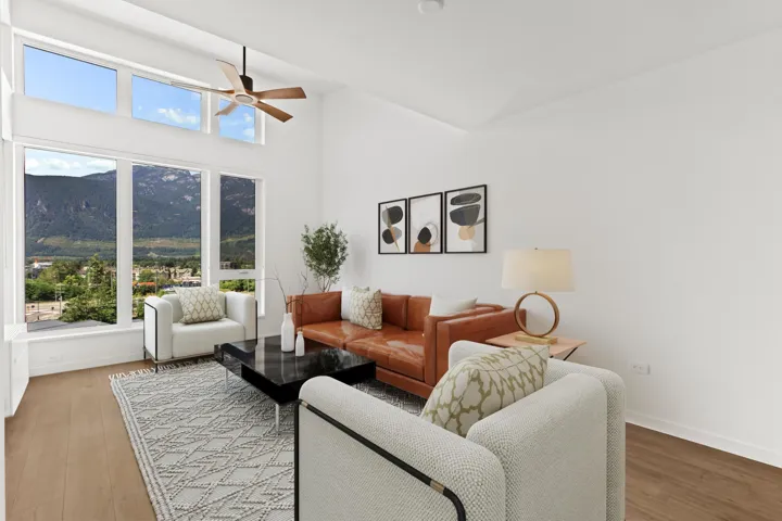 Living room with wood finished floors, a ceiling fan, and high vaulted ceiling