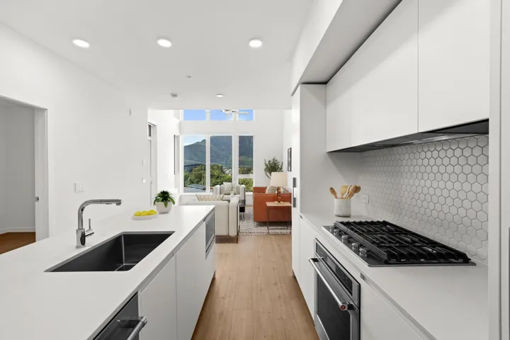 Kitchen with modern cabinets, white cabinetry, light wood-style flooring, stainless steel appliances, and recessed lighting