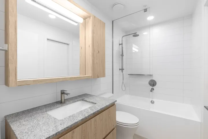 Full bath featuring vanity, bathtub / shower combination, tile walls, and recessed lighting