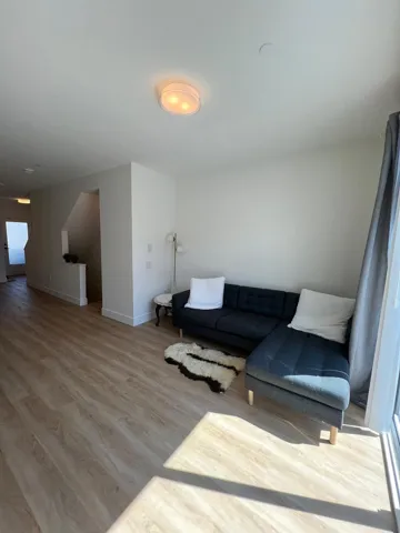 Living room featuring light wood-style flooring and baseboards