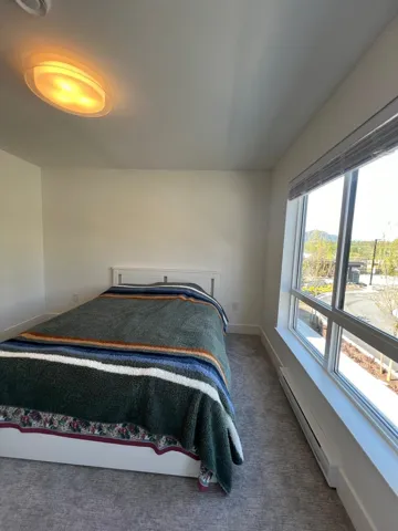 Bedroom with a baseboard radiator and dark carpet