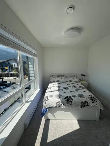 Carpeted bedroom featuring a baseboard heating unit and baseboards