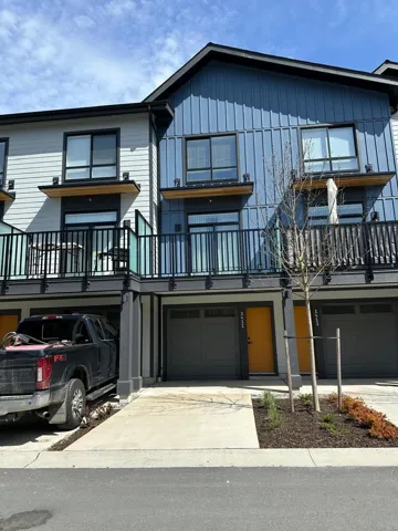 View of front of home featuring a garage, driveway, a balcony, and board and batten siding