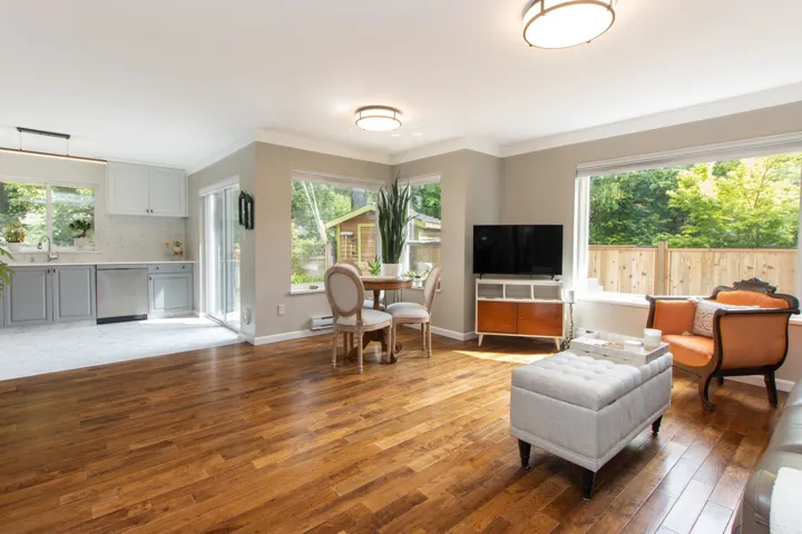 Living area with light wood-style floors, a baseboard heating unit, baseboards, and ornamental molding