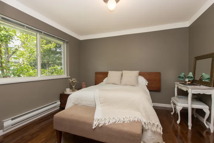 Bedroom featuring a baseboard heating unit, wood finished floors, and baseboards
