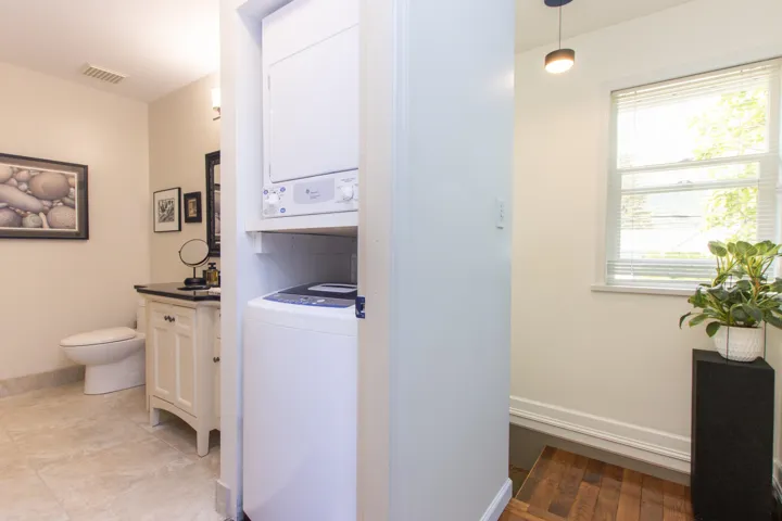 Laundry room featuring stacked washer / drying machine and baseboards