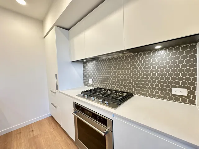 Kitchen featuring white cabinets, appliances with stainless steel finishes, modern cabinets, light wood-style floors, and recessed lighting