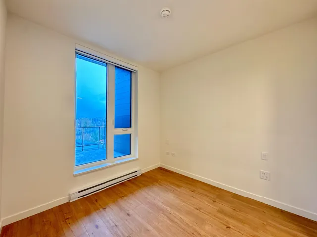 Spare room with a baseboard radiator and light wood-type flooring