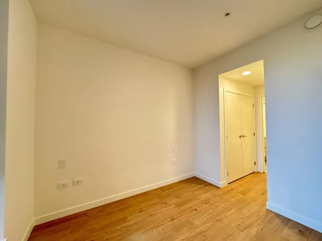 Spare room with baseboards and light wood finished floors