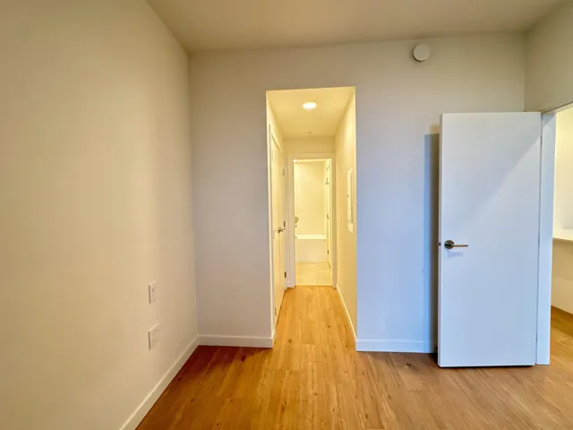 Hallway with light wood-style flooring and baseboards