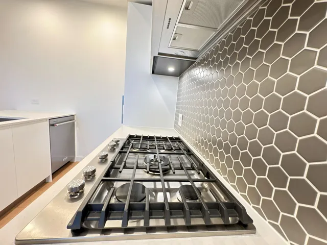 Kitchen view of stainless steel appliances, white cabinetry, and modern cabinets