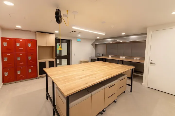 Kitchen with modern cabinets, a breakfast bar, hanging light fixtures, stainless steel range oven, and recessed lighting