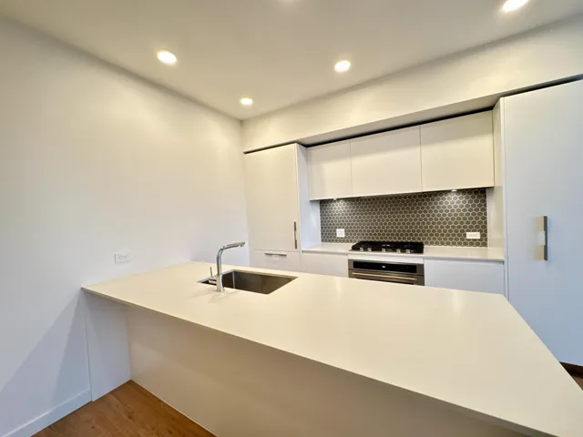 Kitchen featuring modern cabinets, a peninsula, white cabinetry, recessed lighting, and appliances with stainless steel finishes