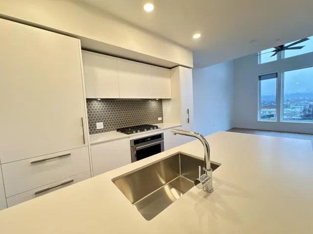 Kitchen with white cabinets, stainless steel appliances, modern cabinets, backsplash, and recessed lighting
