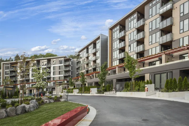 Contemporary multi-story residential buildings featuring balconies with glass railings