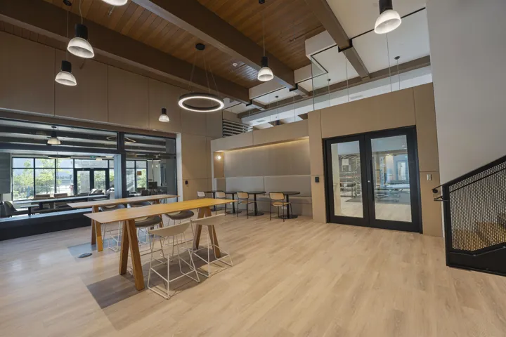 Spacious interior featuring light wood-finish flooring and a wood-paneled ceiling with exposed beams