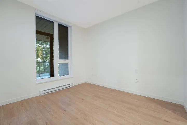 Room featuring wood-finish flooring, white baseboards, and neutral wall tones