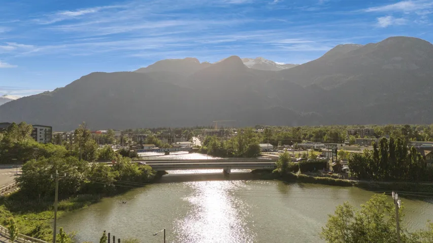 Panoramic mountain backdrop with a river and surrounding green landscape