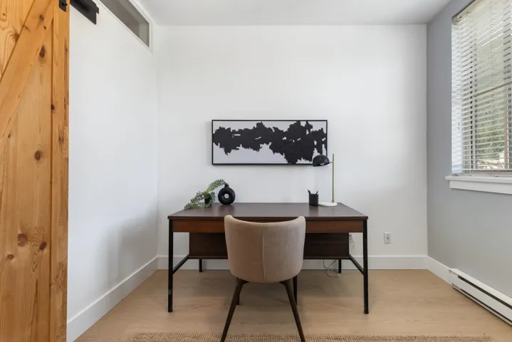 Light-toned wood-finish flooring, white walls, and a window with horizontal blinds