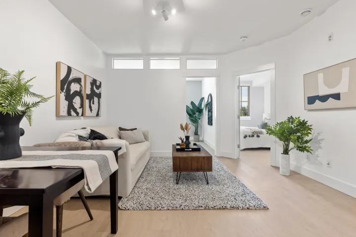 Spacious living area featuring light wood-finish flooring, recessed lighting, and transom windows