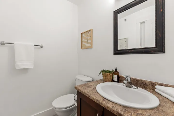 Bathroom vanity with an oval sink, chrome faucet, and a granite-finish countertop
