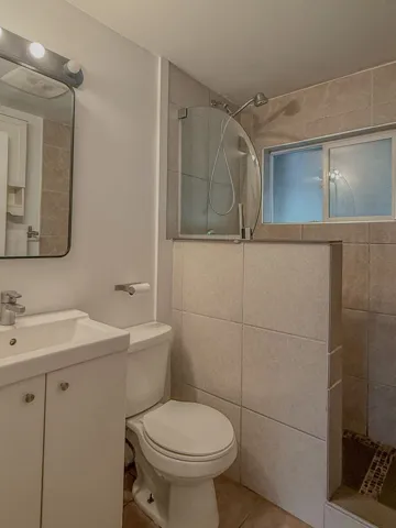 Full bath with walk in shower, vanity, and tile patterned floors