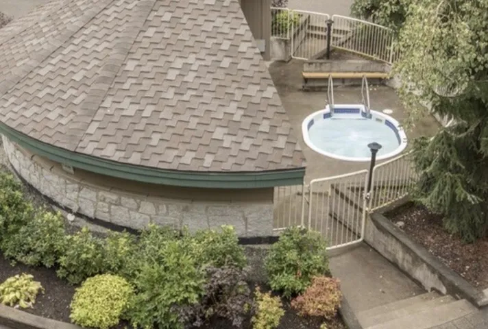 Exterior space with a gate, a shingled roof, and fence