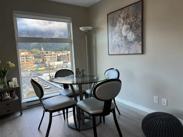 Dining area featuring wood-finish flooring, a large window, and neutral wall tones