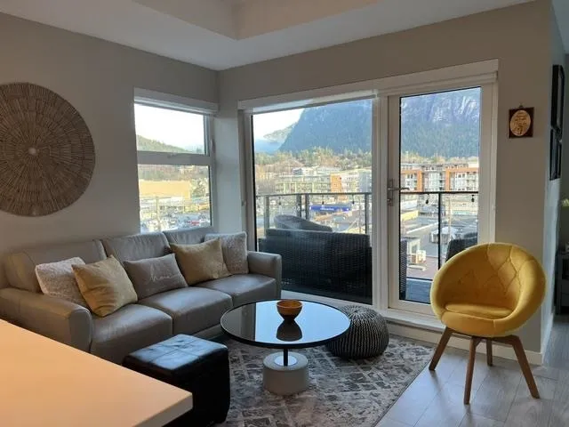 Living area featuring large windows and glass sliding doors, providing ample natural light and showcasing mountain scenery