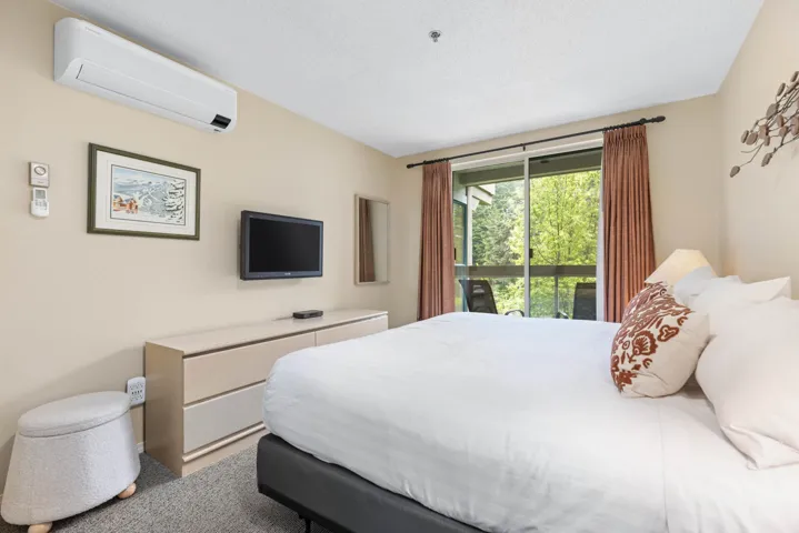 Bedroom featuring a wall mounted air conditioner, access to exterior, and carpet
