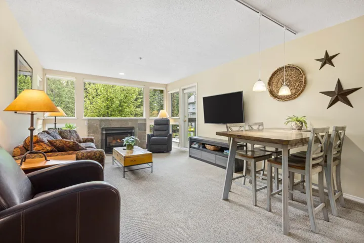 Carpeted living area with a textured ceiling, a fireplace, and rail lighting