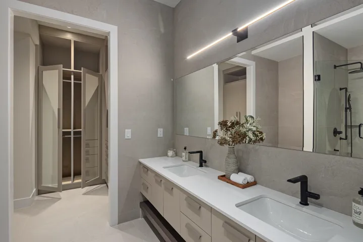 Full bathroom with double vanity and a stall shower