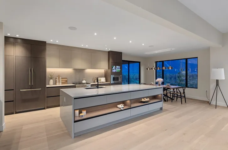 Kitchen featuring modern cabinets, recessed lighting, light countertops, light wood finished floors, and a large island