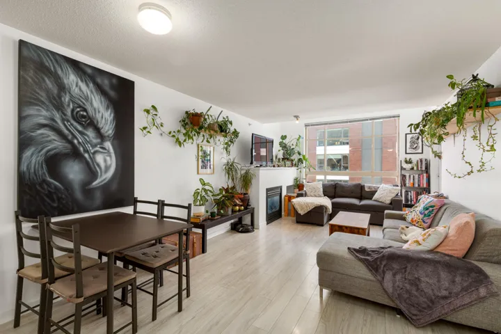 Living area with a glass covered fireplace, light wood-style floors, and a textured ceiling