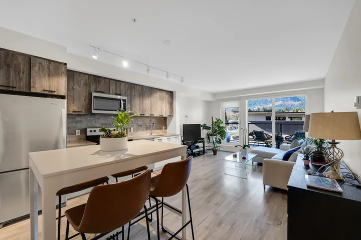 Kitchen with stainless steel appliances, a kitchen island, light wood-style flooring, and dark wood finish cabinetry