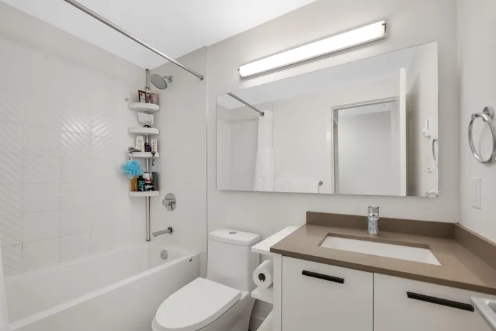 Bathroom featuring vanity and shower / bath combination with curtain